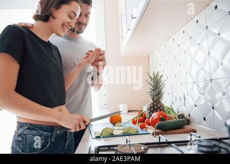 Geschmack, Apple. Junges Paar in der modernen Küche zu Hause am Wochenende morgens Zeit Stockfoto