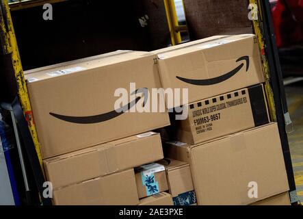 05 Dezember 2019, Brandenburg, Greiz: Pakete mit dem Amazon online Versandhändler logo liegen auf einem Schlepper im DHL-paketzentrum. In der Adventszeit, bis zu 570.000 Sendungen pro Tag Eintreffen am Bestimmungsort aus Greiz, mit 200 zusätzliche Mitarbeiter bereitgestellt. Foto: Monika Skolimowska/dpa-Zentralbild/ZB Stockfoto