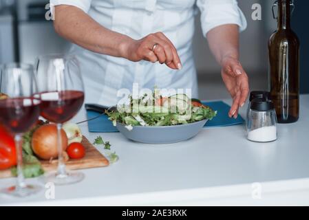 Frau in weißem Hemd die Zubereitung von Speisen in der Küche mit Gemüse Stockfoto