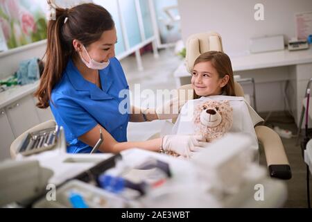 Weibliche Zahnarzt mit Mädchen in der zahnmedizinischen Stuhl Stockfoto