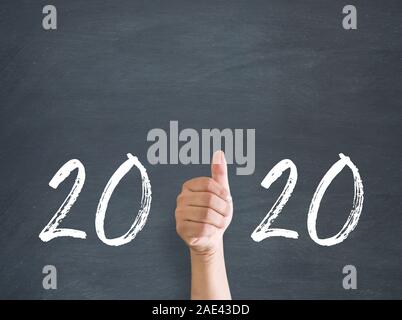 Daumen hoch vor der Tafel mit Meldung 2020 Stockfoto