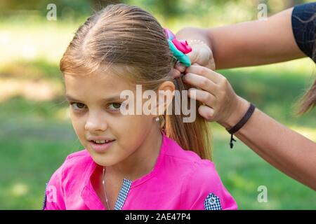 Ein Teenager Girl ist ein Bug auf Long Hair gebunden, ein Picknick, close-up Stockfoto