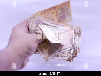 Hand mit Indian Rupee Notizen, weißer Hintergrund Stockfoto