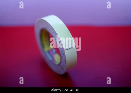 Doppelseitiges Klebeband auf rotem Hintergrund isoliert Stockfoto