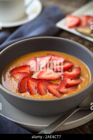 Rick und tröstend squash Porridge mit frischen Erdbeeren Stockfoto