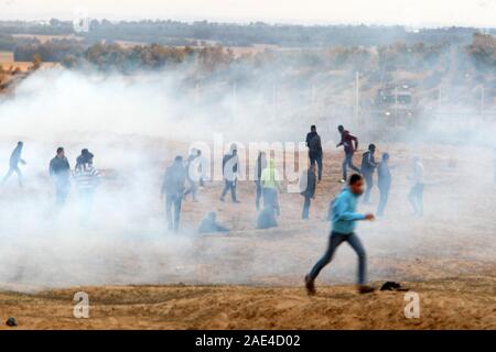 Rafah, Gaza. 06 Dez, 2019. Palästinensische Demonstranten protestieren unter Tränengaskanister durch israelische Streitkräfte bei Zusammenstößen feuerte Tränengas nach einer Demonstration an der Grenze zu Israel osten ofRafah im südlichen Gazastreifen. Am Freitag auf Dacember 06, 2019. 29 Palästinenser verletzt, durch die israelische Armee. Eine medizinische Quelle sagte. Foto von Ismael Mohamad/Quelle: UPI/Alamy leben Nachrichten Stockfoto