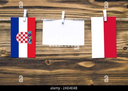 Hängenden Flaggen von Kroatien und Indonesien zu Seil mit wäscheklammer mit Kopie Raum befestigt auf weißem Papier auf Holz- Hintergrund. diplomatischen Beziehungen Stockfoto