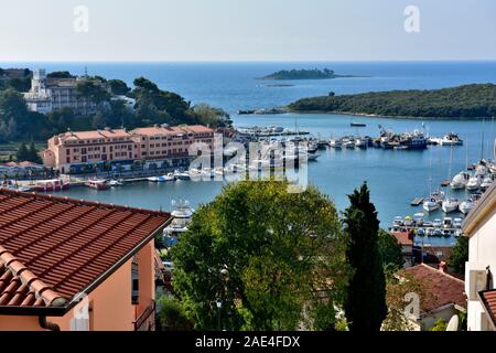 Blick über die Dächer von Gebäuden bis zum Hafen und Boote in der Altstadt von Vrsar, Istrien, Kroatien Stockfoto