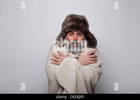 Ältere Menschen, die mit einer Decke und mit einem Hut Schütteln in der Kälte. M Stockfoto