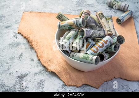 Cash Banknoten der Amerikanischen Dollar Wechsel der verschiedenen Werte stehen auf dem Tisch, als Metapher für das Essen das Leben Werte und eine Erinnerung an die Gebrechlichkeit der Stockfoto