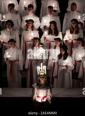 Matilda Bergstrom eine Krone trägt der Kerzen symbolisieren St Lucy, führt ein Abendessen bei Kerzenschein Prozession der London Nordic Chor während der Sankta Lucia service an der York Minster. Bild Datum: Freitag Dezember 6, 2019. Die atmosphärischen Schwedische Service ist eine Feier der St. Lucy, ein sizilianisches mädchen für ihren christlichen Glauben im vierten Jahrhundert den Märtyrertod. Die Krone symbolisiert ein Halo, einer roten Schärpe ihr Martyrium und der Service feiert das Mitbringen von Licht in der Dunkelheit des Winters. Photo Credit: Danny Lawson/PA-Kabel Stockfoto