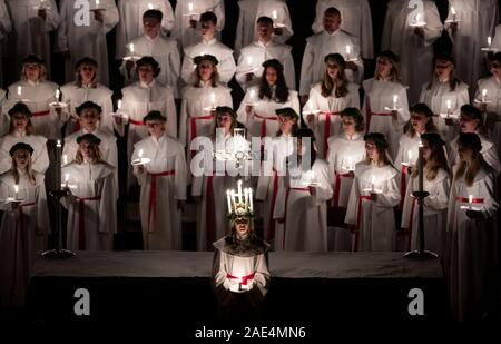 Matilda Bergstrom eine Krone trägt der Kerzen symbolisieren St Lucy, führt ein Abendessen bei Kerzenschein Prozession der London Nordic Chor während der Sankta Lucia service an der York Minster. Bild Datum: Freitag Dezember 6, 2019. Die atmosphärischen Schwedische Service ist eine Feier der St. Lucy, ein sizilianisches mädchen für ihren christlichen Glauben im vierten Jahrhundert den Märtyrertod. Die Krone symbolisiert ein Halo, einer roten Schärpe ihr Martyrium und der Service feiert das Mitbringen von Licht in der Dunkelheit des Winters. Photo Credit: Danny Lawson/PA-Kabel Stockfoto