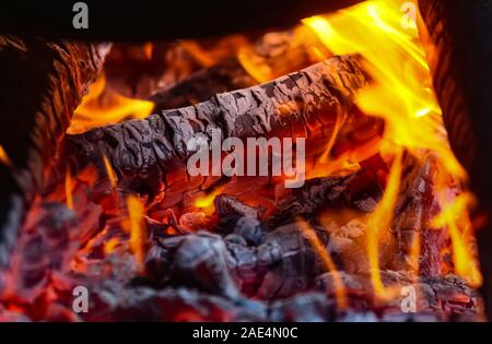 Bukarest, Rumänien, 10. Oktober 2019: Große Stücke Holz Brennen mit rot gelb Flamme unter der Asche und Glut. Stockfoto