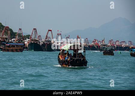 Eine Regierung Arbeiter reinigt das Wasser von Hong Kong Island Aberdeen Hafen mit einem Net, Kommissionierung bis Müll, Müll und andere Verschmutzungen. Stockfoto