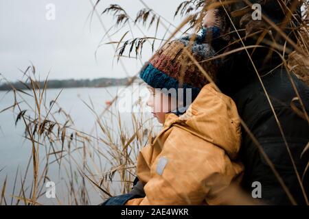 Junge saß auf seiner Väter runde Außen am Meer denken Stockfoto