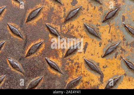 In der Nähe der Alten verwitterten Rostbraun industrielle Anti Slip Metallplatte mit Rautenmuster und verschlissene gelbe Farbe Stockfoto