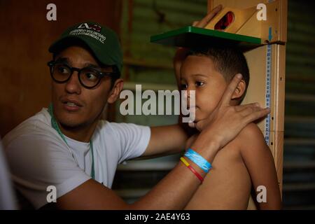 Caracas, Miranda, Venezuela. 29 Nov, 2019. Ein Kind hat seine Höhe als Teil eines medizinischen Check-up von Freiwilligen übernommen. Eine große Krise geschieht in dem südamerikanischen Land von Venezuela. Eine korrupte Regierung und massive Inflation hat einen erheblichen Mangel im Gesundheitswesen verursacht. Die in armen Slums sind stark leiden. Einige NGOS, die versuchen, so viel wie möglich zu helfen. Eine solche NGO ist Impronta Venezuela. Impronta ist eine venezuelanische gemeinnützige Organisation, mit dem Ziel der Umgestaltung der Wirklichkeit, die uns Herausforderungen geboren wurde, Möglichkeiten für die am stärksten gefährdeten Bevölkerungsgruppen zu r Stockfoto