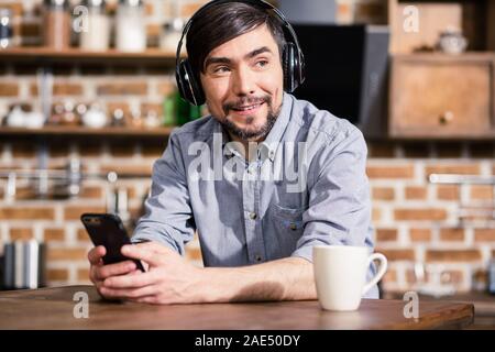 Freundlich lächelnden Mann Musik zu Hause genießen Stockfoto