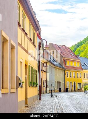 Bunte Häuser an einer Kopfsteinpflasterstraße im Kurort Bad Schandau Sachsen Deutschland. Stockfoto