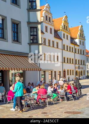 Der Marktplatz ist von traditionellen Gebäuden, Hotels und Restaurants im Freien in der Altstadt Torgau Sachsen gesäumt. Stockfoto