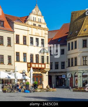 Der Marktplatz ist von traditionellen Gebäuden, Hotels und Restaurants im Freien in der Altstadt Torgau Sachsen gesäumt. Stockfoto