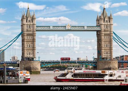 London - 05. September 2019: Iconic Double Decker Überquerung der Tower Bridge mit einem Wassertaxi kommen in für Passagiere, London September 05, 2019 Stockfoto