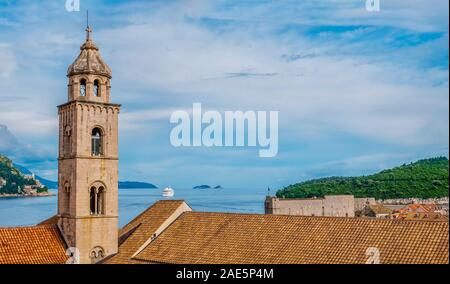 Konzentrieren Sie sich auf eine mittelalterliche Kathedrale Glockenturm und orange Dachziegel in Dubrovnik, Kroatien, mit dem Meer und die Küste im Hintergrund. Stockfoto
