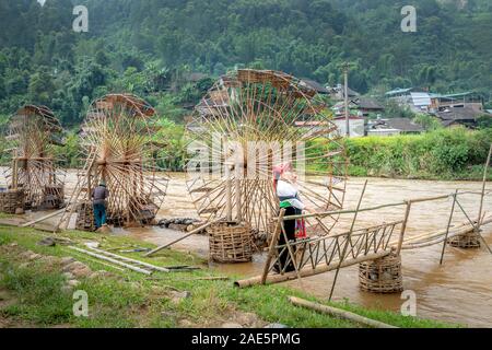 Pu Luong, Thanh Hoa Provinz, Vietnam - September 19, 2019: weibliche Touristen in traditionellen thailändischen Kleidung weiter zu riesige Wasser- Räder Stockfoto