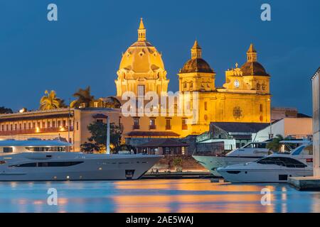 Dämmerung Blick auf Boote neben den historischen Gebäuden der ummauerten Altstadt von Cartagena in Kolumbien. Stockfoto