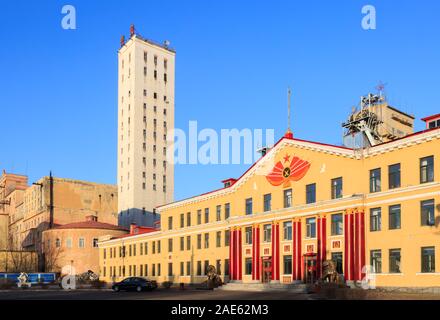 Hegang City, China-15 FEB 2018: Das Bürogebäude von Xingan Coal Mine, die Chinesen auf der Spitze des Turms ist der Name von Mir, dem Chinesischen umgeben von Gat Stockfoto