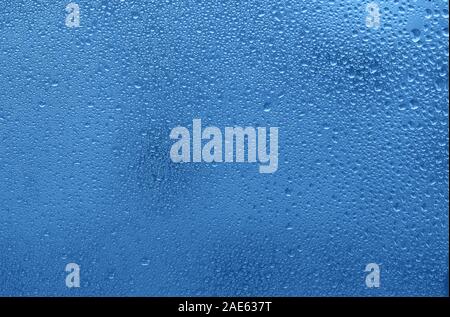 Fenster mit Wassertropfen. Blau gefärbten Hintergrund. Stockfoto