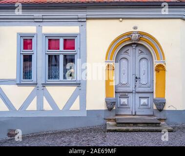 Dekorative Holztür und -Fenster sowie aus Stein gehauene Architrave in einem Holzrahmenhaus in der historischen Altstadt Tangermünde Sachsen-Anhalt Deutschland. Stockfoto