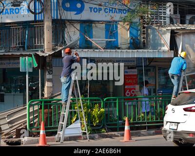 Bangkok, Thailand - Dezember 4, 2019: Ein Arbeiter stehen auf der Leiter mit Bohrung für die Installation der neuen Aluminium Dach zu machen Stockfoto