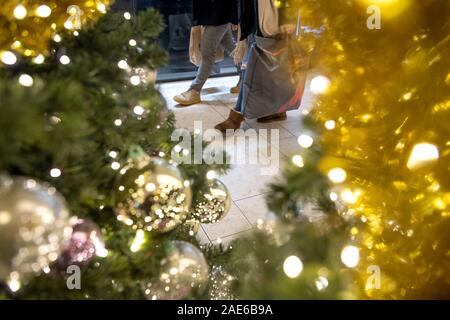 Hannover, Deutschland. 06 Dez, 2019. Während der Adventszeit, die Leute gehen mit Tüten hinter geschmückten Weihnachtsbaum. Credit: Sina Schuldt/dpa/Alamy leben Nachrichten Stockfoto