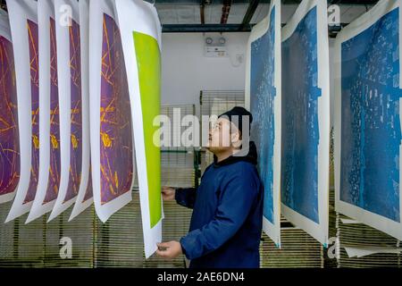 Pu'er, der chinesischen Provinz Yunnan. 5 Dez, 2019. Student Zhong Ping, luftgetrocknete Halbzeuge Jueban Holzschnitt Gemälde an der Holzschnitt Studio von Pu'er-Universität in Pu'er-Stadt, im Südwesten der chinesischen Provinz Yunnan, Dez. 5, 2019. Die Jueban Holzschnitt ist eine Art der Holzschnitzerei Technik aus der Stadt Pu'er in den 1980er Jahren. Credit: Hu Chao/Xinhua/Alamy leben Nachrichten Stockfoto