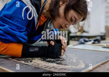 Pu'er, der chinesischen Provinz Yunnan. 5 Dez, 2019. Student Zeng Dehui von kunst-Institut macht Jueban Holzschnitt Malerei an der Holzschnitt Studio von Pu'er-Universität in Pu'er-Stadt, im Südwesten der chinesischen Provinz Yunnan, Dez. 5, 2019. Die Jueban Holzschnitt ist eine Art der Holzschnitzerei Technik aus der Stadt Pu'er in den 1980er Jahren. Credit: Hu Chao/Xinhua/Alamy leben Nachrichten Stockfoto