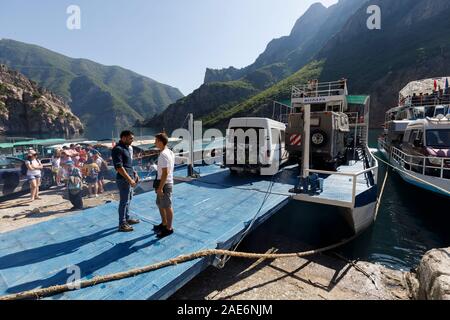 Koman, Albanien, dem 7. Juli 2019: Fähre ist geladen mit Autos und Passagiere in Koman, Komani See, ein 35 km langer Stausee in den Dinarischen Alpen Stockfoto