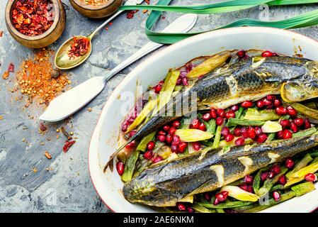 Pelengas gebacken mit Gemüse und Granatapfel. gekocht gebraten Fisch in einer Auflaufform. Stockfoto