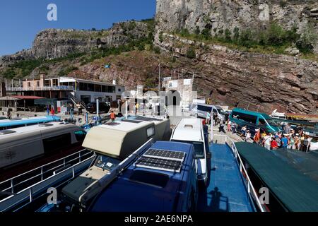 Koman, Albanien, dem 7. Juli 2019: Fähre ist geladen mit Autos und Passagiere in Koman, Komani See, ein 35 km langer Stausee in den Dinarischen Alpen Stockfoto