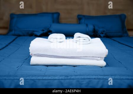 Saubere, weiße Handtücher auf hotel Bett mit blau Bettwäsche Stockfoto