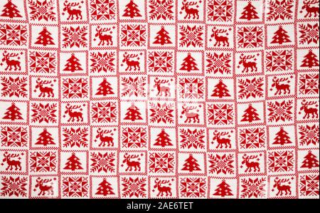 Weiß Gestrick mit roten Elche, Tannenbaum und Schneeflocke skandinavischen Stil geometrische Verzierung Weihnachten Hintergrund Stockfoto