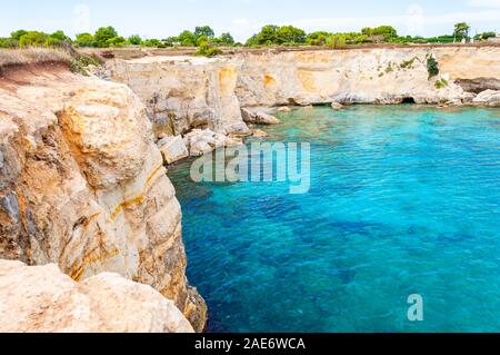 Kristallklare Wasser bei Torre Sant Andrea Strand mit seiner zerklüfteten Küste Landschaft. Ionische Meer Bucht in Melendugno, Apulien, Italien Stockfoto