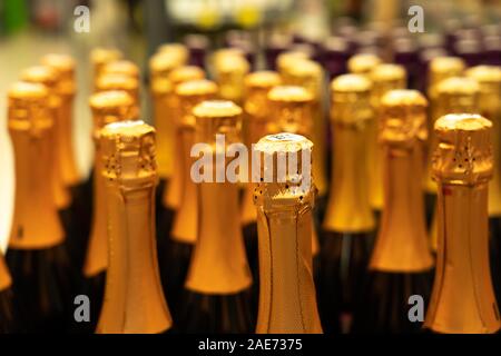 Champagner Flaschen in der Vinothek. perspektivische Ansicht Detail der goldenen Champagner flaschen Tops geordnet im Regal. Selektive konzentrieren. Stockfoto