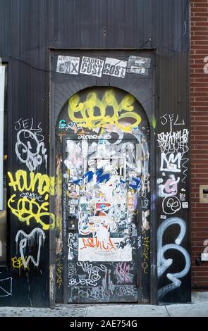 Ein Manhattan Tür Collage auf Eighth Ave. knapp unter der 14. Straße mit Graffiti, Sticker und Tagging. In New York City. Stockfoto
