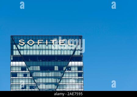 Das Logo und der obere Teil des Sofitel Hotel in Darling Harbour in Sydney, Australien auf einem sonnigen blauen Himmel Tag Stockfoto