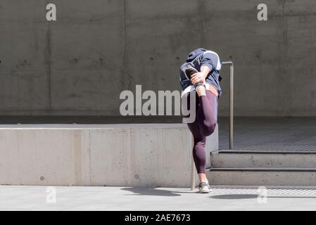 Eine hintere oder hinter den Blick auf eine Person, die mit einem Geländer aus Stahl, dehnen und Aufwärmen vor Training in Sydney, Australien Stockfoto