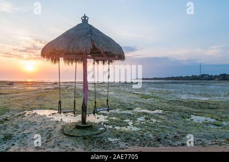 Sonnenuntergang mit Regenschirm und Schwingen, Nusa Ceningan, Bali, Indonesien Stockfoto