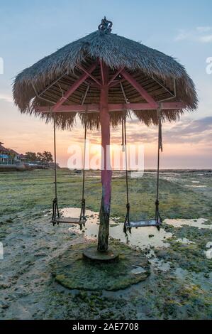 Sonnenuntergang mit Regenschirm und Schwingen, Nusa Ceningan, Bali, Indonesien Stockfoto