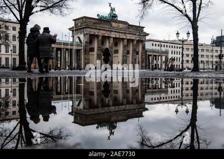 Berlin, Deutschland. 07 Dez, 2019. Das Brandenburger Tor ist in einer Pfütze von Regen nieder. Credit: Paul Zinken/dpa/Alamy leben Nachrichten Stockfoto