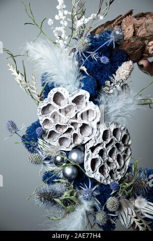 Nahaufnahme der Hand ein blumengeschäft Holding a Christmas Kranz mit Tannenzweigen Stockfoto